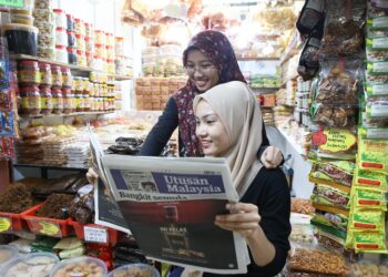 MAIZATUL Najiha Mohd. Isa (depan) dan Nurul Nabihah Zulkifli membaca Utusan Malaysia di Kompleks Pekan Rabu, Alor Setar. - UTUSAN/SHAHIR NOORDIN