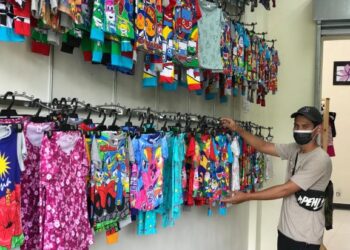 KHAIRUL Ikhwan Kalik yang menjual pakaian dewasa dan kanak-kanak di Plaza IMT-GT Bukit Bunga, Tanah Merah, Kelantan, berharap pintu sempadan kembali dibuka. - UTUSAM/ROSLIZA MOHAMED