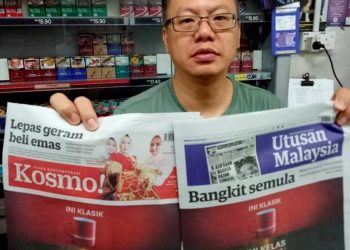 SEOW Tiam Fat menunjukkan akhbar Utusan Malaysia dan Kosmo! di kedainya di Bandar Segamat, Johor. - UTUSAN/FARAHWAHIDA AHMAD