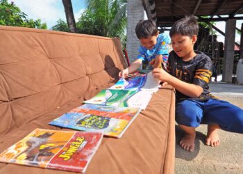 Tuah Iskandar Abdul Rasid, murid Sekolah Kebangsaan (SK) Gelang Patah menjemur buku sekolahnya yang basah akibat ditenggelami banjir melanda Kampung Baru Muafakat Gelang Patah semalam.