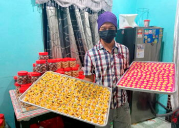 ZAIHANODIN Jamaludin menunjukkan pelbagai jenis kuih yang dibuat di rumahnya untuk dijual sempena hari raya di Kampung Sungai Kuali, Serkat. -UTUSAN/MUHAMMAD ZIKRI