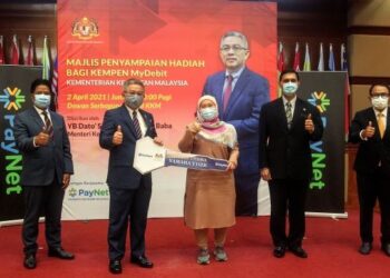 ADHAM Baba (dua kiri) menyampaikan hadiah kempen MyDebit kepada pemenang, Nur Aisyah Nadira Che Om (tiga kanan) berupa motosikal Yamaha Y15ZR pada majlis penyampaian hadiah Kempen MyDebit Kementerian Kesihatan di Putrajaya. - UTUSAN/FAISOL MUSTAFA