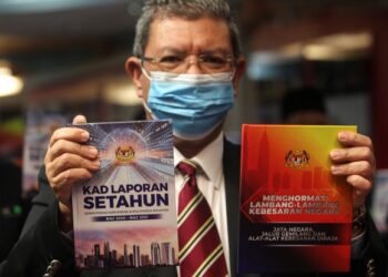 SAIFUDDIN Abdullah menunjukkan buku Menghormati Lambang-lambang Kebesaran Negara dan Kad Laporan Setahun KKMM pada Majlis Pelancaran Buku Menghormati Lambang-lambang Kebesaran Negara dan Kad Laporan Setahun KKMM di Kementerian Komunikasi dan Multimedia Malaysia di Putrajaya, hari ini. - UTUSAN/ FAISOL MUSTAFA