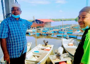 MUSTAFFA Bakar (kiri) menunjukkan sebahagian sangkar ikan yang berdepan dengan kerugian akibat kualiti air sungai tercemar di Sungai Semerak, Pasir Puteh, Kelantan, hari ini. - UTUSAN/TOREK SULONG