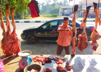 ZAKARIA Awang memotong daging lembu sebelum dijual kepada pelanggan yang datang ke gerainya di Jalan Pasir Puteh-Kota Bharu berhampiran Kampung Jambu Merah, Melor pada 27 Februaru 2021. - UTUSAN/YATIMIN ABDULLAH