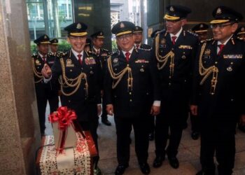 ISKANDAR Halim Sulaiman (kiri) mengetip kad perakam waktu pada hari terakhir beliau bertugas di Putrajaya hari ini. Yang turut hadir Alexander Nanta Linggi (dua kiri). - UTUSAN/FAISOL MUSTAFA