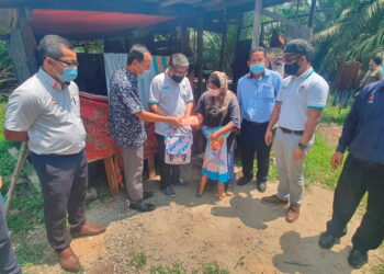 RADZIAH Bohari (empat dari kanan) menerima sumbangan daripada Pengarah SPAN Wilayah Selatan, Padhil Abd. Hadi (tiga dari kiri) ketika melawat keluarga tersebut di rumah mereka di Kampung Parit Sulaiman, Telok Kerang. Pemberita: MUHAMMAD ZIKRI