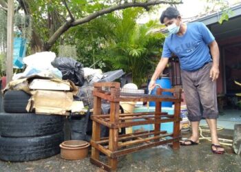 OMAR Jusuh membersihkan barang-barang yang ditenggelami banjir di rumahnya di Taman Wira Indah di Lubok China, Melaka. – UTUSAN/MUHAMMAD SHAHIZAM TAZALI