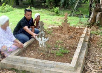 NAZRI Kamal Al-Bentan (tengah) melihat sebuah makam berusia lebih 400 tahun yang ditemukan di sebuah kampung di Chengkau, Rembau baru-baru ini.-UTUSAN/NOR AINNA HAMZAH