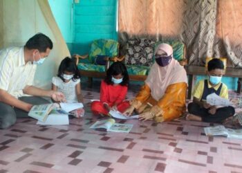 ZARINA Sidik (tengah) bersama Penolong Kanan Hal Ehwal Murid, Fatimah Ibrahim dan guru bahasa Arab dan Pendidikan Islam, Mohd. Ariffin Kasmon membantu anak-anak Mohd. Asrul Karman yang tiada peranti mengikuti PdPR di Kampung Parit Patah, Pontian, Johor, semalam. – UTUSAN/MUHAMMAD ZIKRI