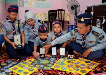 HAMIDUN Ahmad menunjukkan koleksi pingat dan lencana yang diperoleh sepanjang penglibatan dalam
pengakap kepada cucu dan anaknya ketika ditemui di rumahnya di Beseri, Perlis semalam. – UTUSAN/NUR
NAZLINA NADZARI