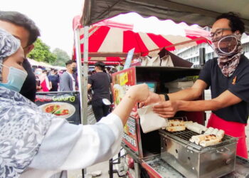 YUSDI Hidayat Abdul Yusof melayan seorang pelanggan yang singgah membeli Bako Gulung di bazar Ramadan Taman Pauh, Bukit Mertajam, Pulau Pinang.