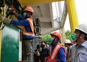 MOHD. Elmi Anas (kanan) melihat kerja-kerja pemotongan bekalan dilakukan di sebuah premis yang disyaki terlibat dengan kegiatan penyambungan bekalan elektrik secara haram di Permatang Pauh, Pulau Pinang semalam.-UTUSAN/ ISWAN SHAFIQ ISA