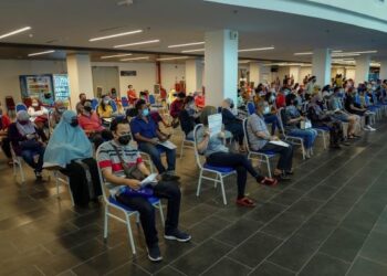 PENERIMA vaksin Covid-19 menunggu giliran di ruangan pemerhatian selepas menerima suntikan vaksin di Pusat Pemberian Vaksin (PPV) Axiata Arena Bukit Jalil. - UTUSAN/FARIZ RUSADIO