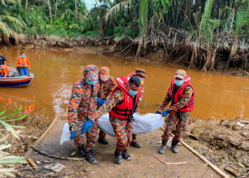 ANGGOTA bomba membawa naik mayat mangsa lemas di Jambatan Sungai Sabak Bernam di Hutan Melintang hari ini. -IHSAN JBPM