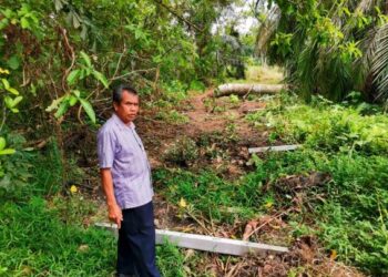 MUSA Harun menunjukkan tiang pagar yang dirobohkan pihak berkuasa di tanah kebun yang diusahakannya di Kampung Banjar, Teluk Intan. - UTUSAN/AIN SAFRE BIDIN