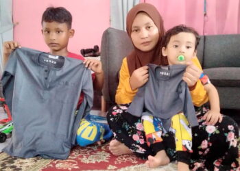 MUHAMMAD Ammar Rizqi (kiri) menunjukkan baju raya yang dibeli ibunya sebagai menunaikan hasrat arwah bapanya yang meninggal dunia dalam kemalangan jalan raya pada 21 April lalu ketika ditemui di Bagan Serai baru-baru ini. -UTUSAN/WAT KAMAL ABAS