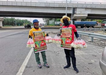 MOHD. Firdaus Mohd.  Zaidi (kanan) bersama rakan semasa menjadi peniaga jalanan di Teluk Intan namun kini mengubah perniagaan dengan menghantar pesanan ke rumah pelanggan. – UTUSAN/AIN SAFRE BIDIN