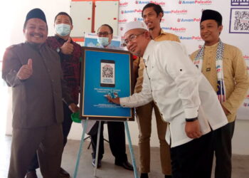 ZAMRI Hashim menurunkan tanda tangan sebagai gimik Pelancaran QR Code Tabung Palestin di Ipoh hari ini. -UTUSAN/ ZAKI SALLEH