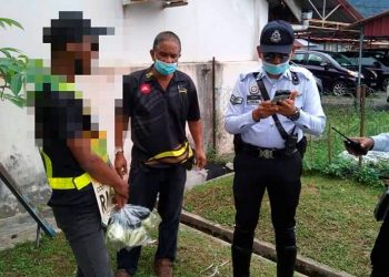 ANGGOTA polis menyaman peniaga jalanan yang berniaga di persimpangan lampu isyarat di Taiping baru-baru ini. - IHSAN FB POLIS DAERAH TAIPING