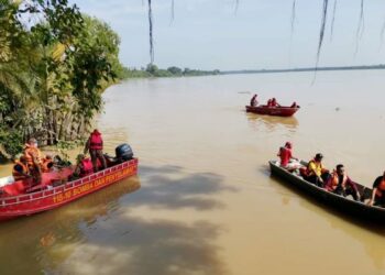 ANGGOTA bomba menjalankan operasi mencari seorang pelajar, Muhammad Amirnur Hadi Ahmad Kamal yang hilang selepas menyelamatkan adiknya daripada dihanyutkan arus deras ketika mandi di Sungai Perak di Kampung Tebing Rebak, Hutan Melintang, Bagan Datuk, semalam. – FOTO/AIN SAFRE BIDIN