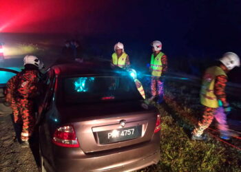 ANGGOTA bomba mengeluarkan mangsa yang tersepit dalam kereta yang terlibat kemalangan di Kilometer 16, Jalan Raya Timur-Barat Fasa 2, Gerik-Kupang di Gerik hari ini. - GAMBAR IHSAN JBPM