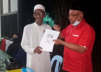 Bekas ahli UMNO, Khusaini Suib (kiri) menyerahkan borang keahlian Bersatu kepada Md. Nayan Salleh di Tanjung Piandang, Parit Buntar semalam. -UTUSAN/WAT KAMAL ABAS