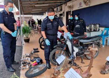 A. Asmadi Abdul Aziz (tengah) menunjukkan motosikal dan komponen curi  yang ditemukan semula setelah menahan lima individu kumpulan curi motosikal dalam serbuan minggu lalu pada sidang akhbar di sini hari ini.