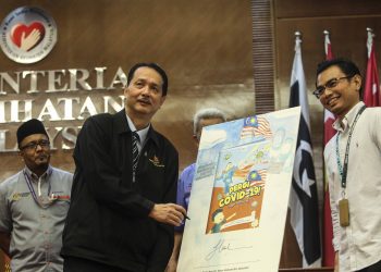 DR. Noor Hisham Abdullah menandatangani buku komik `Pergi Covid-19!' pada Majlis Sesi Libat Urus Media bersama Ketua Pengarah Kesihatan di Putrajaya. - UTUSAN/FAISOL MUSTAFA