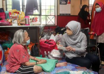 RINA Mohd. Harun beramah mesra dengan mangsa banjir ketika mengadakan lawatan ke PPS Kota Warisan di Sekolah Kebangsaan Kota Warisan, Sepang, Selangor. - FOTO/FAISOL MUSTAFA