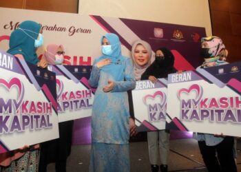 RINA Mohd. Harun beramah mesra bersama penerima Geran MyKasih Kapital  pada Majlis Penyerahan Geran MyKasih Kapital di Sepang, Selangor. - UTUSAN/FAISOL MUSTAFA