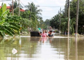 PENDUDUK kampung meredah banjir untuk melihat keadaan rumah mereka di RTB Bukit Changgang, Kuala Langat, Selangor. - UTUSAN/FAISOL MUSTAFA