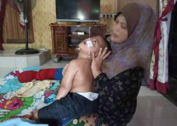 SAREHA Ismail memeriksa keadaan Muhammad Shahril Arsyad Mohd. Rosbaidi di Kampung Kedai Buloh, Kota Bharu. – UTUSAN/ROSLIZA MOHAMED