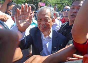 MUHYIDDIN Yassin melambai ke arah ratusan penyokong-penyokongnya yang berhimpun di luar pekarangan Ibu pejabat SPRM di Putrajaya, semalam selepas dipanggil memberi keterangan berhubung siasatan penyelewengan program Jana Wibawa. - UTUSAN/FAISOL MUSTAFA