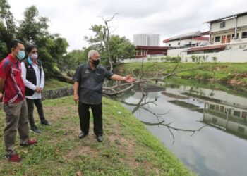 HASSAN Abdul Karim (kanan) meninjau keadaan Sungai Buluh di Kawasan Perindustrian Pasir Gudang, Johor yang kotor dan busuk sehingga dikategorikan sebagai antara sungai paling tercemar di negara ini. 
– UTUSAN/KHAIRUL MOHD. ALI