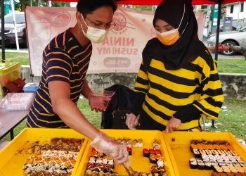 WAN Isma Ezzaqri Othman dan Nur Zahwa Zakaria menjual sushi di Jalan Seremban- Jelebu, ketika ditemui Utusan Malaysia di Seremban, semalam.-UTUSAN/NOR SHAFAWATI YUP