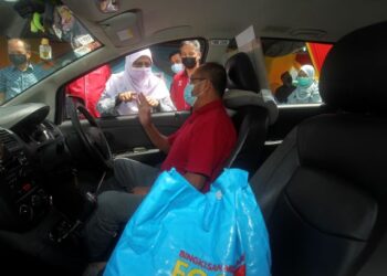 RODZIAH Ismail (tengah) beramah mesra dengan pemandu teksi ketika menyerahkan sumbangan food basket kepada pemandu teksi dan bas sekolah pada program Bingkisan Mesra Selangor di Dataran Bandar Baru Salak Tinggi Walk Sepang, Selangor.- UTUSAN/FAISOL MUSTAFA