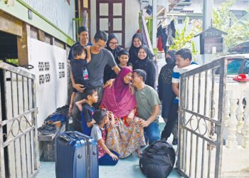 WAHI Ali gembira menyambut kepulangan anak-anak dan cucunya menyambut Aidilfitri di Kampung Pulau Rusa, Kuala Terengganu, semalam. - UTUSAN/PUQTRA HAIRRY ROSLI