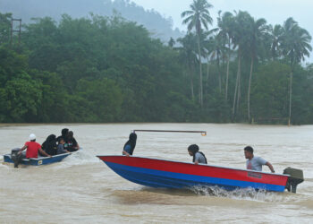 SEKUMPULAN  remaja dan kanak-kanak bermain air di padang bolasepak yang ditenggelami banjir semenjak tiga hari lalu meskipun paras air Sungai Dungun mulai surut ketika tinjauan di Kampung Minda, Bukit Besi. -UTUSAN/ PUQTRA HAIRRY