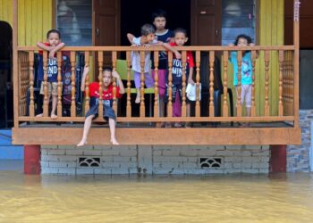 BEBERAPA kanak-kanak dilihat sedang berada di beranda rumah sambil melihat air banjir yang sedang meningkat naik di Kampung Chalok Kedai hari ini. Hujan berterusan sejak kelmarin menyebabkan beberapa kawasan di negeri ini mulai banjir.Sekretariat Jawatankuasa Pengurusan Bencana negeri berkata, setakat pukul 1 pagi ini, dua pusat pemindahan sementara (PPS) dibuka di Setiu sekali gus menjadikan jumlah keseluruhan yang beroperasi kini adalah tiga termasuk di Kuala Nerus. -UTUSAN/PUQTRA HAIRRY