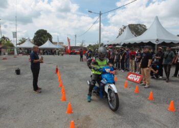 FAHRULRAZI Zailan (depan kanan) dan Wazi Abdul Hamid (kiri) mengadakan demonstrasi cara penunggangan motosikal dengan betul kepada belia pada Program Pencarian Bakat di Dataran Sadiman, Bukit Changgang, Selangor. - UTUSAN/FAISOL MUSTAFA