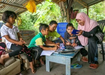 SEKUMPULAN kanak-kanak berkongsi telefon bimbit bagi mendapatkan akses internet untuk pembelajaran secara dalam talian di Kampung Padang Balai, Kuala Nerang, Kedah, baru-baru ini. – UTUSAN/SHAHIR NOORDIN