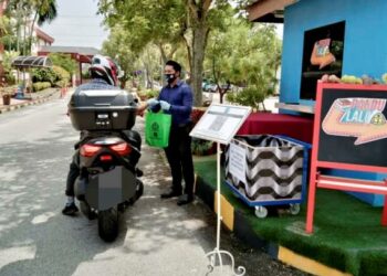 KAKITANGAN Perbadanan Perpustakaan Awam Pulau Pinang (PPAPP) menyerahkan buku pinjaman kepada salah seorang pengunjung perpustakaan pandu lalu di Permatang Pauh, Pulau Pinang di sini semalam.