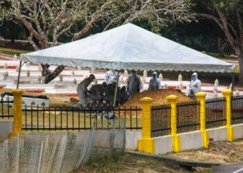 ANGGOTA Batalion Ke-15 RAMD yang memakai PPE mengendalikan pengkebumian jenazah Ujang Mormin di Pusara RAMD di Port Dickson hari ini. - FOTO/MUHAMMAD IZZAT TERMIZIE