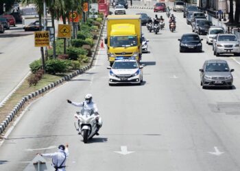 ANGGOTA polis mengiring kenderaan kurier membawa dos vaksin Covid-19 yang tiba di Hospital Raja Permaisuri Bainun (HRPB), Ipoh, Perak, hari ini. - UTUSAN/ZULFACHRI ZULKIFLI