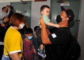 BALI Anak Jalang (kanan) mendukung anaknya yang lebih setahun tidak berjumpa ketika disambut isterinya, Donna Alicia sebaik tiba dari Singapura di Terminal Larkin Sentral, Johor Bahru. - FOTO/RAJA JAAFAR ALI