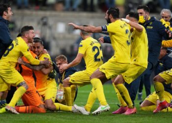 PEMAIN Villarreal memeluk penjaga gol, Geronimo Rulli yang muncul wira selepas menyudahkan penalti terakhir dan menyekat sepakan David de Gea untuk muncul juara Liga Europa di Gdansk, Poland hari ini. - AFP