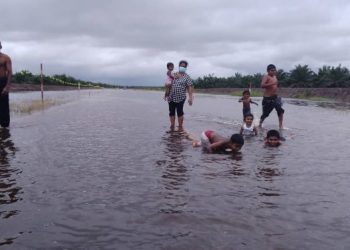 SEKUMPULAN kanak-kanak bermain air banjir di Jalan Bagan Serai-Selama hari ini. -UTUSAN/ WAT KAMAL ABAS