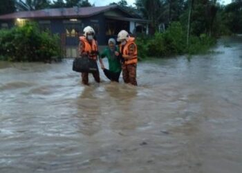 ANGGOTA bomba memindahkan warga emas ke tempat yang selamat dalam kejadian banjir di Bidor hari ini. - GAMBAR JBPM