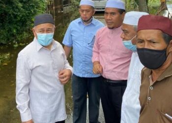 Tuan  Ibrahim Tuan Man (kiri) meninjau sistem perparitan di kawasan Pasir Tumboh, Kota Bharu hari ini. UTUSAN / ROHANA MOHD NAWI